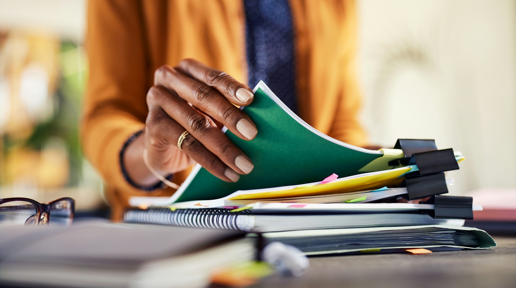 African american woman checking documents while working at creative office