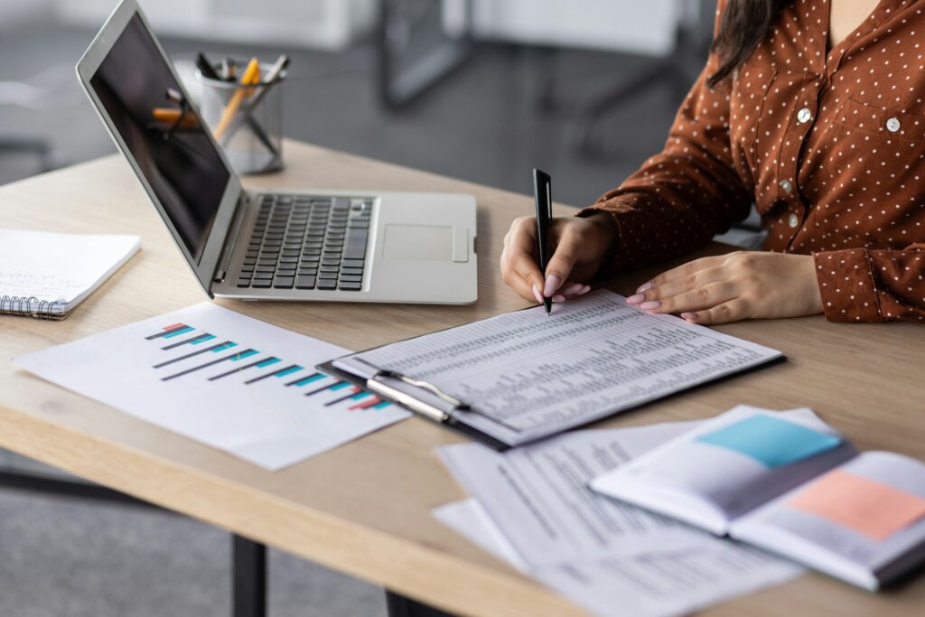 Hands of financier close-up, female accountant on paper work, fills forms, and enters data into